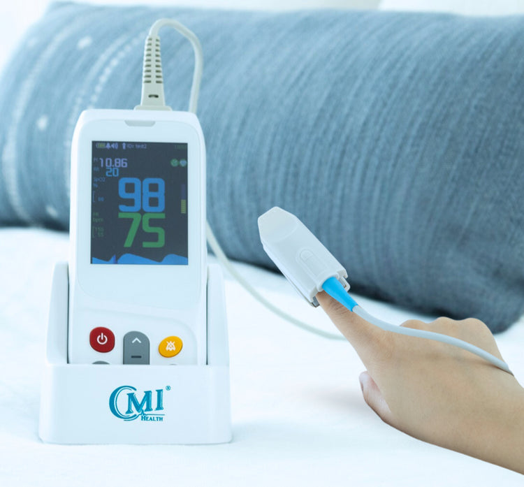 CMI Health CH-100 Handheld Pulse Oximeter in charging dock with finger sensor attached, displaying SpO2 and pulse rate readings during use