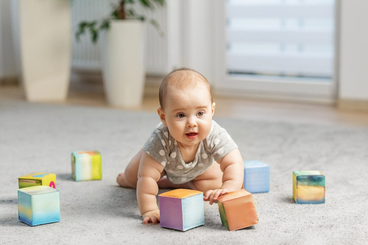 Baby crawling on a rug and playing with soft blocks during an awake period