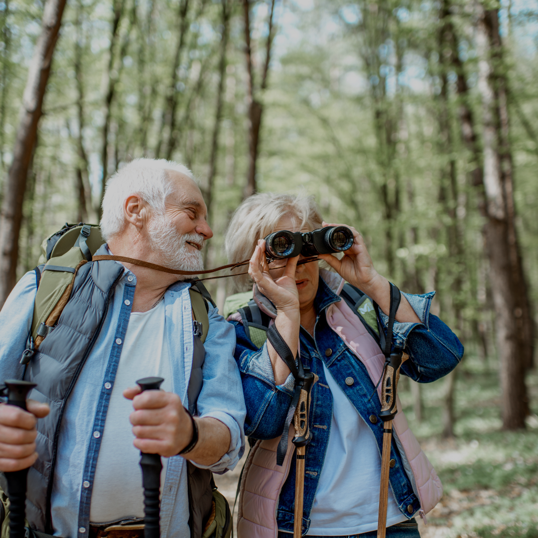 An older couple look happy and excited while hiking outdoors and being active
