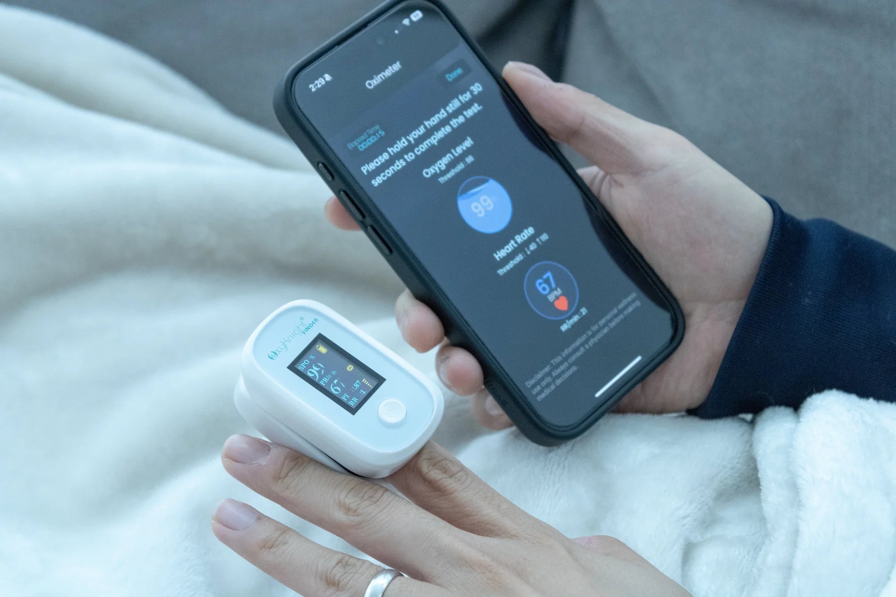 Pulse oximeter displaying real-time data connected to a smartphone health app.